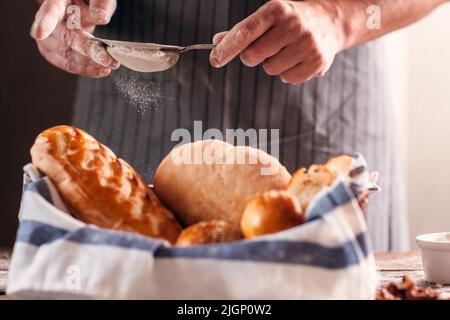 Boulanger méconnaissable finissant sa pâtisserie en gros plan Banque D'Images