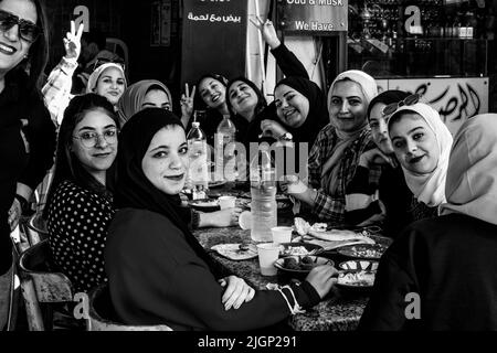 Un groupe de jeunes femmes jordaniennes dégusteront un petit-déjeuner devant Un café à Aqaba, dans le gouvernorat d'Aqaba, en Jordanie. Banque D'Images