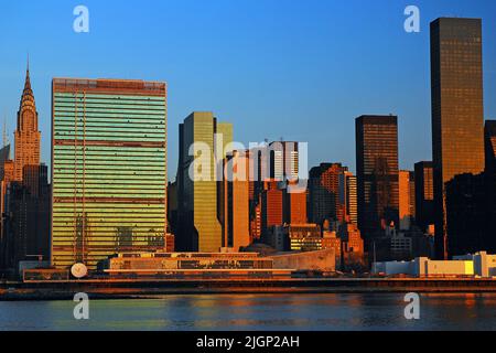 Le ciel du lever du soleil se reflète dans les fenêtres de Midtown Manhattan et dans les gratte-ciels de New York, y compris les Nations Unies Banque D'Images