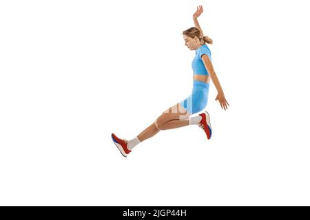 Technique de triple saut. Photo de studio d'une athlète féminine en uniforme sportif sautant isolé sur fond blanc. Concept de sport, d'action, de mouvement, de vitesse. Banque D'Images