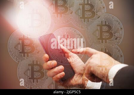 Homme d'affaires mains tout en poussant avec le doigt le concept de téléphone portable des investissements dans les bitcoins en utilisant E commerce. Banque D'Images