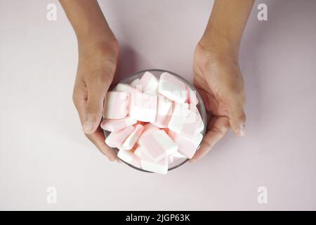 guimauve sucreries dans un bol sur bleu Banque D'Images