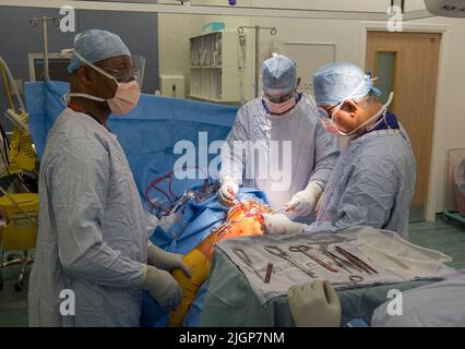 Un chirurgien et le personnel du NHS effectuent une chirurgie du genou, également connue sous le nom d'arthroplastie, dans un hôpital du NHS. Banque D'Images