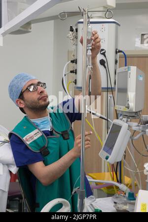 Un anesthésiste vérifie la progression du patient pendant une opération de l'hôpital NHS. Banque D'Images