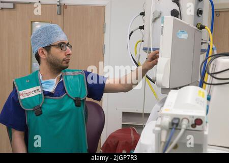 Un anesthésiste vérifie la progression du patient pendant une opération de l'hôpital NHS. Banque D'Images