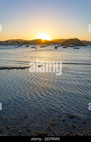 Coucher de soleil derrière les collines et se reflète dans les eaux de mer de la ville de Buzios sur la côte nord de Rio de Janeiro Banque D'Images