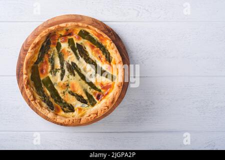 Quiche. Tarte aux asperges maison ou quiche au fromage et aux épinards sur fond de table en bois blanc. Quiche traditionnelle française. Vue de dessus. Banque D'Images