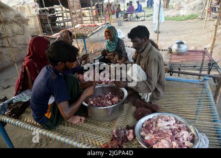 11 juillet 2022, Lahore, Punjab, Pakistan: Les Gitans pakistanais ont répandu de la viande salée pour sécher sur un charpai recueilli à différents endroits pendant les 2nd jours de la célébration musulmane Eid al-Adha ou du Festival du sacrifice à Lahore. Les musulmans célèbrent Eid al-Adha ou Fête du sacrifice, la deuxième des deux fêtes islamiques célébrées dans le monde entier marquant la fin du pèlerinage annuel ou du Hajj à la ville sainte saoudienne de la Mecque et commémorant la volonté du prophète Ibrahim, Abraham aux chrétiens et aux juifs, de sacrifier son fils. Pendant les vacances, qui dans la plupart des endroits dure quatre jours, musulmans Slaugh Banque D'Images