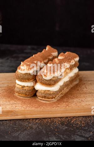 Dessert Tiramisu gâteau sur un plateau sur un fond sombre dans un café Banque D'Images