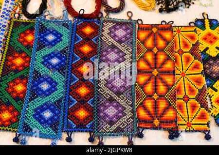 Bracelets de huichol faits à la main avec différentes couleurs et motifs au marché de nuit à Guadalajara, au Mexique. Souvenirs artisanaux mexicains traditionnels Banque D'Images