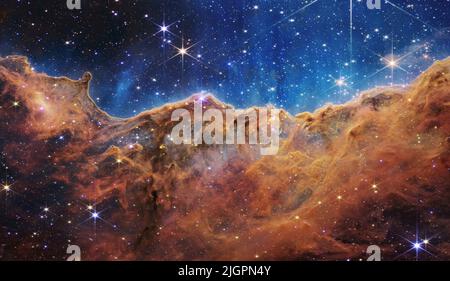 Ce paysage de « montagnes » et de « vallées » parsemé d’étoiles étincelantes est en fait le bord d’une région voisine, jeune et formant des étoiles, appelée NGC 3324 dans la nébuleuse de Carina. Capturée dans la lumière infrarouge par le nouveau télescope spatial James Webb NASAs, cette image révèle pour la première fois des zones précédemment invisibles de naissance des étoiles. Crédit obligatoire : NASA, ESA, CSA et STSci via CNP crédit : dpa Picture Alliance/Alay Live News Banque D'Images