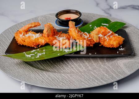 Crevettes à la noix de coco frites servies avec une sauce cocktail sur une assiette Banque D'Images