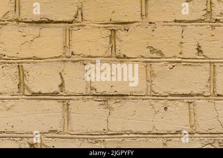 Vieux mur de briques rayé peint de couleur jaune. Arrière-plan texturé de mur vintage. Vue panoramique du mur jaune vide, peut être utilisé pour le design intérieur. Banque D'Images