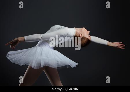 la ballerine élégante a fait une déflexion. la photo prend dans le studio sur un fond sombre. Banque D'Images