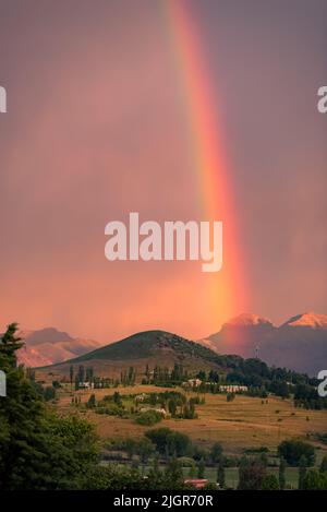 Un arc-en-ciel dans un ciel au coucher du soleil sur une colline à Clarens, Afrique du Sud Banque D'Images