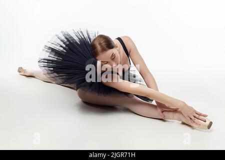la ballerine élégante a fait un fléchissement. photo dans le studio sur un fond blanc. Banque D'Images