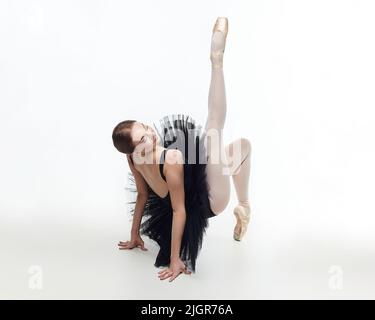 la ballerine élégante a fait un fléchissement. photo dans le studio sur un fond blanc. Banque D'Images
