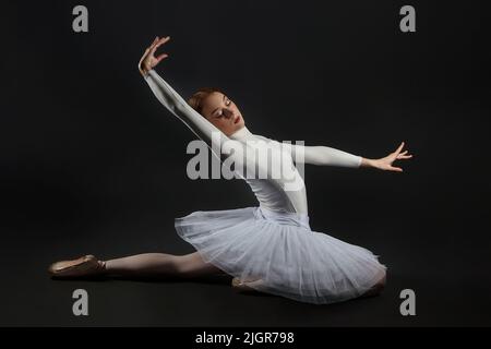 la ballerine élégante a fait une déflexion. la photo prend dans le studio sur un fond sombre. Banque D'Images