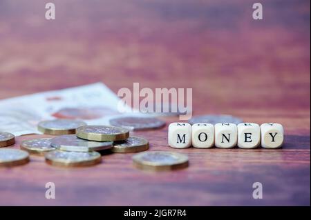 le mot argent sur des cubes en bois avec des pièces de livre à côté Banque D'Images