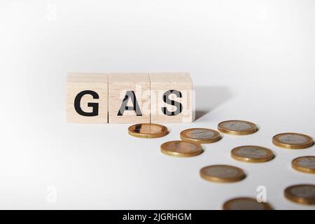 Pièces en euros avec cubes en bois montrant le mot gaz comme symbole de crise du gaz présenté par la guerre de la Russie contre l'Ukraine Banque D'Images