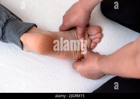 Thérapeute professionnel offrant un massage thaïlandais traditionnel des pieds et de la semelle dans un traitement thérapeutique de relaxation. Réflexologie. Banque D'Images