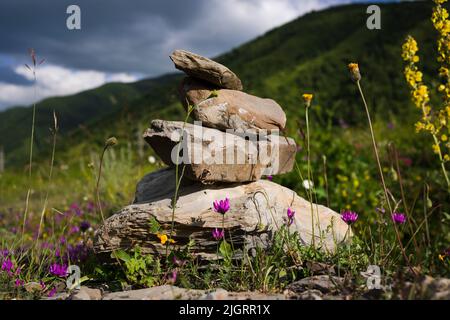 Pile de pierres avec des pierres équilibrées sur fond de montagne flou Banque D'Images