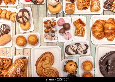 Ensemble de plateaux en carton blanc avec bonbons, desserts et palmiers au chocolat, cupcakes, beignets au chocolat, boules de chocolat et noix de coco et palmiers à sucre sur le woo Banque D'Images