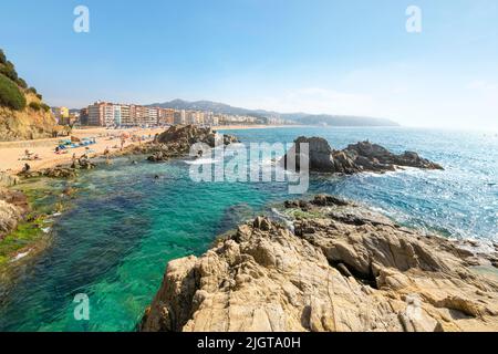 Vue sur la plage de sable, le rivage rocheux et la station balnéaire de Lloret de Mar, en Espagne, sur la côte de la mer Méditerranée de la Costa Brava. Banque D'Images