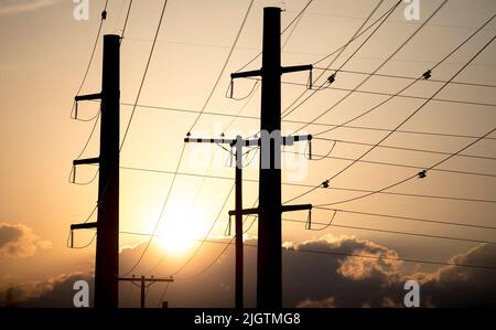 (220713) -- HOUSTON, 13 juillet 2022 (Xinhua) -- le soleil se couche derrière les lignes de transmission de puissance au Texas, aux États-Unis sur 11 juillet 2022. Le Electric Reliability Council of Texas (ERCOT) a demandé lundi aux résidents et aux entreprises de réduire leur consommation d'énergie car l'indice thermique dépassait 100 degrés Fahrenheit dans environ la moitié de l'État du centre-sud des États-Unis. Cette vague de chaleur a commencé il y a plus d'une semaine et continue de se renforcer, défiant le réseau électrique de l'État. Les températures quasi-records dans la plupart des États du Texas ont forcé divers événements en plein air à être retardés ou annulés en raison de problèmes de sécurité. (Tél Banque D'Images