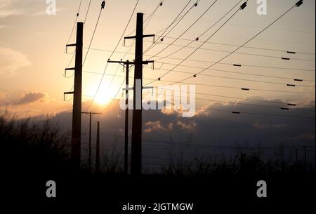 (220713) -- HOUSTON, 13 juillet 2022 (Xinhua) -- le soleil se couche derrière les lignes de transmission de puissance au Texas, aux États-Unis sur 11 juillet 2022. Le Electric Reliability Council of Texas (ERCOT) a demandé lundi aux résidents et aux entreprises de réduire leur consommation d'énergie car l'indice thermique dépassait 100 degrés Fahrenheit dans environ la moitié de l'État du centre-sud des États-Unis. Cette vague de chaleur a commencé il y a plus d'une semaine et continue de se renforcer, défiant le réseau électrique de l'État. Les températures quasi-records dans la plupart des États du Texas ont forcé divers événements en plein air à être retardés ou annulés en raison de problèmes de sécurité. (Tél Banque D'Images