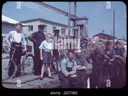 Selon les notes: 70 pcs. Lame alésée. + 5 bidons avec lame d'oramade. Bateaux, chantiers navals, mer, gens. Un groupe d'hommes et un garçon au port de Klova: (FR. V :) Henry Larsson, Ernst Alexandersson, Rickard Corneliusson (à vélo), Rolf Larsson, Valfrid Eliasson, Emil Sörensson, Stig Zackarson, Wilhem et Lennart Alexandersson. Les cinq derniers ont été équipage à Suède GG 372.Ishuset en arrière-plan. N° de film 124 plusieurs hommes et un garçon se tiennent à un port. Deux des hommes tiennent un vélo. En arrière-plan, le bois à pâte est en stock. Banque D'Images