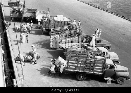 Voyage africain, acquisition de Jeddahsom -term: Livres et matériel d'archives.35 Images en série. La photo a été prise vers le 1961-08-15. Un navire déchargeant des marchandises dans un port. Sur le quai sont plusieurs camions qui prennent soin des marchandises. Banque D'Images