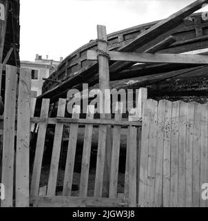 23. Italie. Le journal photo est disponible à B.M.A. + albums photo. Acquisition : livres et documents d'archives. Photos prises 1959-11-04,11 photos en série. Selon les notes: Italie. Golfe, Varaze, 4/11 -59. Barge pendant la réparation. Un plus grand bateau est à l'intérieur d'une clôture sur une plage. En arrière-plan est une société. Banque D'Images