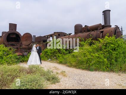 Couple récemment marié devant l'ancienne locomotive de la ligne Beyrouth–Damas, gouvernorat du Nord, Tripoli, Liban Banque D'Images