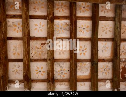 Vieux plafond de lambris en bois et avec des dessins de fleurs en jaune Banque D'Images