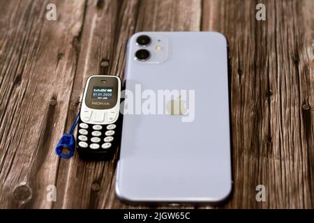 Le Caire, l'Egypte, 11 juin 2022: Apple iPhone 11 avec 6,1inch liquide Retina HD haute définition écran et un petit vieux mini téléphone cellulaire Nokia avec un ke Banque D'Images