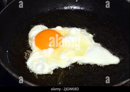 œuf de poulet frit dans une poêle à frire avec de l'huile ou du ghee, un repas rapide et facile pour le petit déjeuner et le dîner, foyer sélectif Banque D'Images