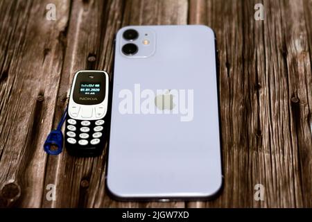 Le Caire, l'Egypte, 11 juin 2022: Apple iPhone 11 avec 6,1inch liquide Retina HD haute définition écran et un petit vieux mini téléphone cellulaire Nokia avec un ke Banque D'Images