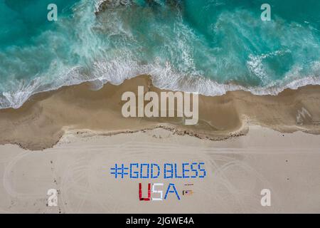 Riviera Beach, Floride, États-Unis. 2nd avril 2020. Les chaises de plage énoncent '#God Bless USA' sur la plage du Palm Beach Marriott Singer Island Beach Resort and Spa. Le personnel énonce une nouvelle phrase positive chaque jour pour les résidents et les clients pendant que les plages sont fermées pour ralentir la propagation du coronavirus COVID-19. (Image de crédit : © Greg Lovett/ZUMA Press Wire) Banque D'Images