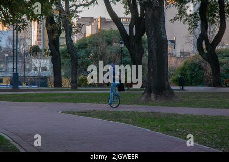 Un jeune homme à cheval sur un monocycle dans le Parque Lezama dans le district de San Telmo, Buenos Aires, Argentine Banque D'Images