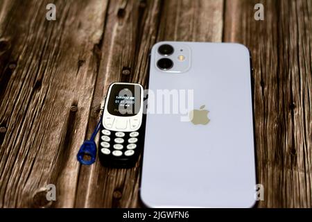 Le Caire, l'Egypte, 11 juin 2022: Apple iPhone 11 avec 6,1inch liquide Retina HD haute définition écran et un petit vieux mini téléphone cellulaire Nokia avec un ke Banque D'Images