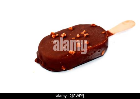 Bâton de glace au chocolat enrobé et recouvert d'une couche de chocolat noir avec des noix, de glace riche aromatisée dans le craquant au chocolat brun et Banque D'Images