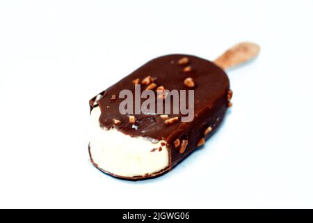 Crème glacée riche à la vanille, au chocolat au lait brun craquant et à l'amande rôtie, isolée sur fond blanc, crème glacée à la vanille recouverte d'un bâton et d'un c Banque D'Images