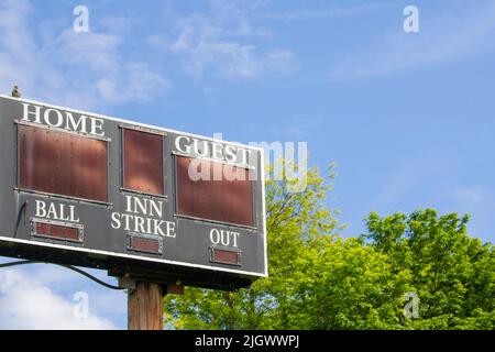 Le tableau de bord des matchs de sport affiche les résultats de l'équipe à la maison et des clients sur un ciel bleu avec des arbres Banque D'Images