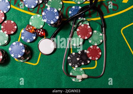 jetons de poker, argent, stéthoscope sur table de blackjack. Banque D'Images