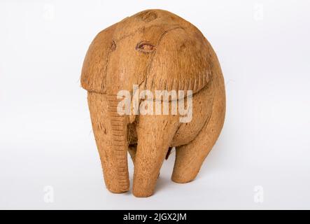 Une figurine souvenir d'un éléphant fait de noix de coco sur un fond blanc isolé. Banque D'Images