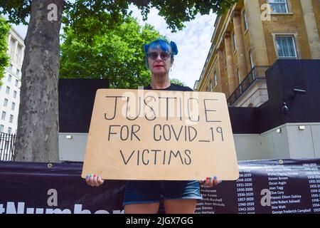 Londres, Angleterre, Royaume-Uni. 13th juillet 2022. Un manifestant détient un écriteau « Justice pour les victimes de la COVID-19 ». Les militants de l'organisation, pas des numéros, ont accroché des bannières avec des noms de personnes qui ont perdu la vie à cause du coronavirus devant Downing Street alors que les morts de covid britanniques dépassent 200 000. (Image de crédit : © Vuk Valcic/ZUMA Press Wire) Banque D'Images