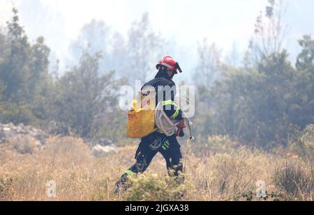 Feu dans une zone ouverte près du site archéologique Velika Mrdakovica dans l'arrière-pays de Vodice, en Croatie, sur 13 juillet 2022. Environ 30 pompiers et une douzaine de véhicules sont au sol, et deux Canadairs se sont joints aux forces terrestres pour éteindre l'incendie. Il y a des forêts de pins au-dessus, une faible végétation et des bâtiments en danger. Photo: Dusko Jaramaz/PIXSELL Banque D'Images