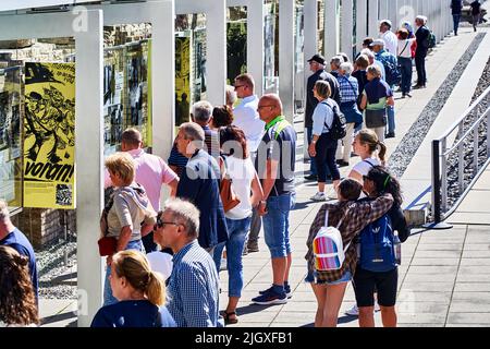 Berlin, Allemagne, 21 juin 2022: Les touristes devant les panneaux d'affichage à la topographie de la place de la terreur apprennent les atrocités du régime nazi Banque D'Images