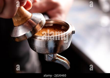 Café Barista holding portafilter et altérer l'expresso. Banque D'Images